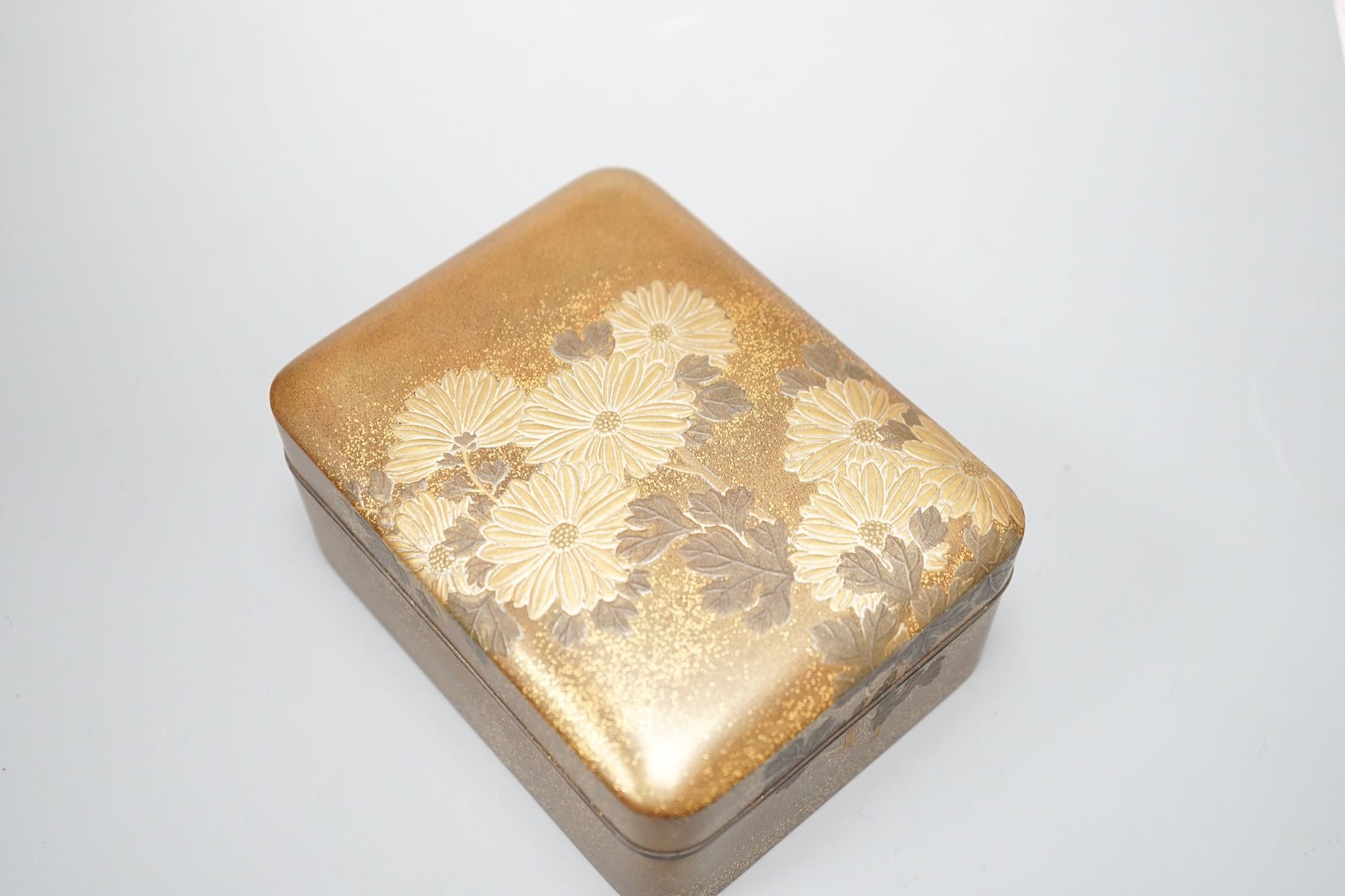 A Japanese small rectangular hiramakline (?) gold-ground box and cover decorated with chrysanthemums, 10 x 8cm